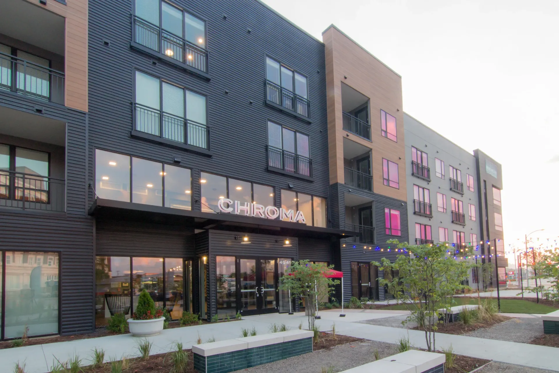 Exterior view of a modern multifamily building with balconies and a CHROMA sign.