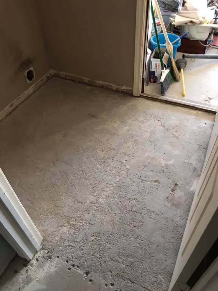 A room with a mop and bucket on the floor.