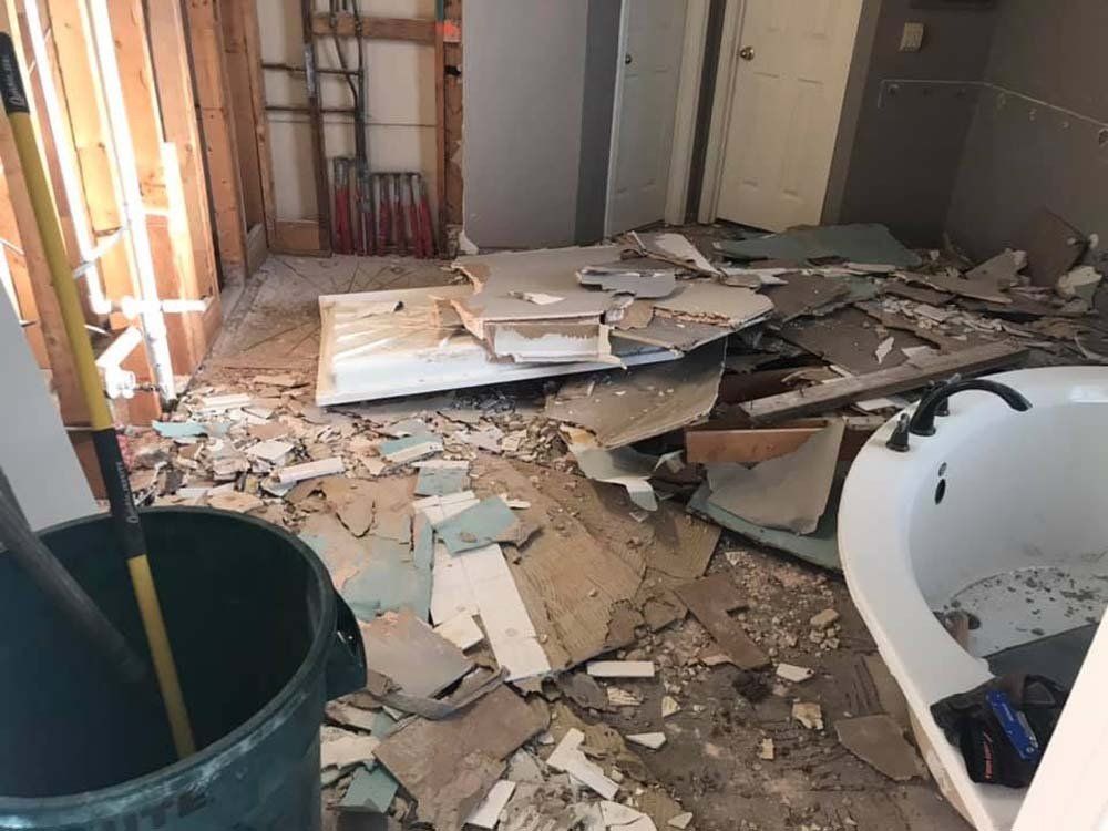 A bathroom under construction with a bathtub and a trash can.