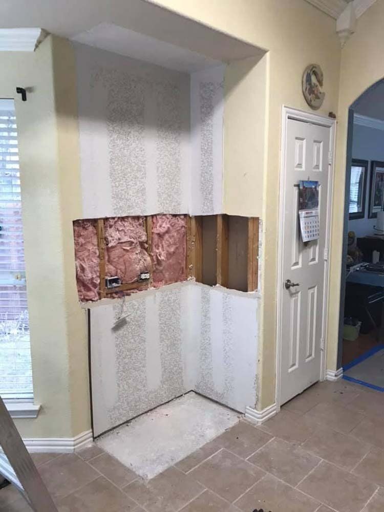 A room with a hole in the wall and a door.