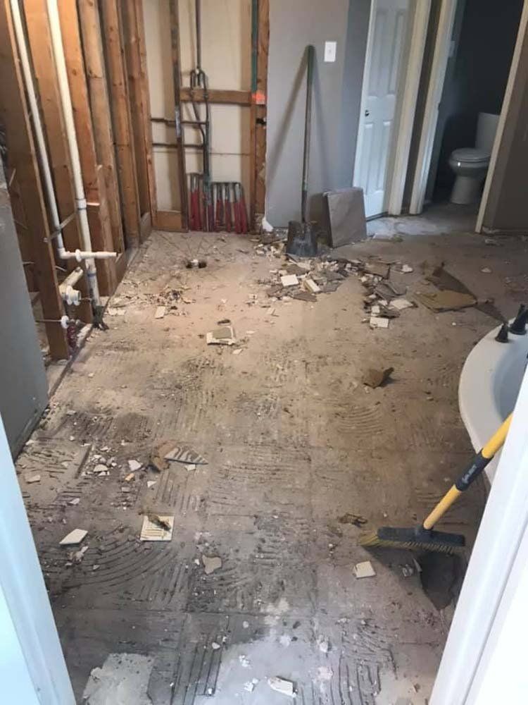 A bathroom under construction with a lot of trash on the floor.