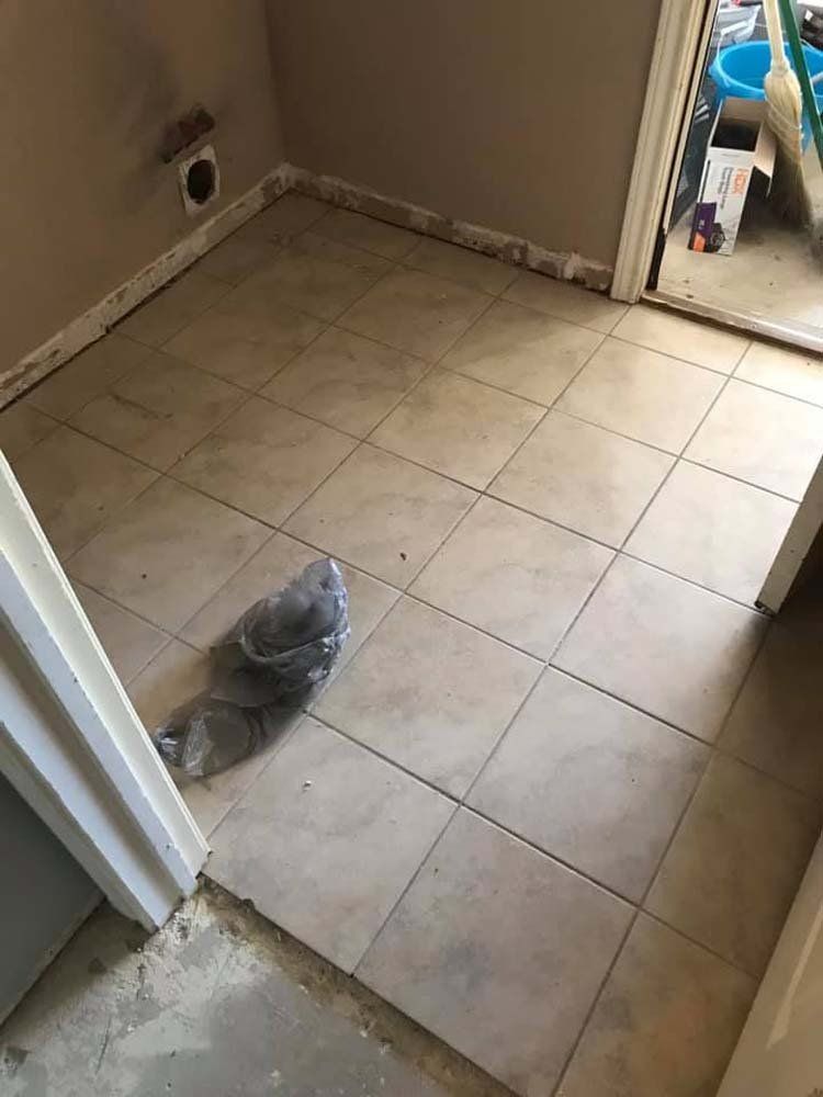 A room with a tiled floor and a bag on the floor.