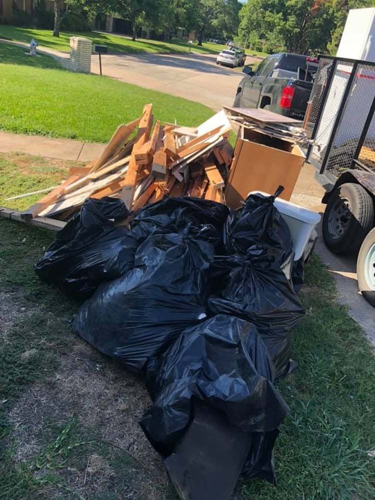 A pile of garbage bags sitting on the side of a road.