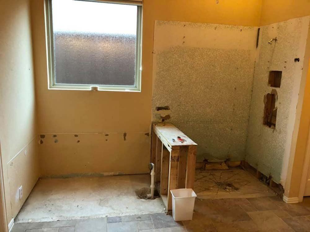 A room with a window and a trash can in it