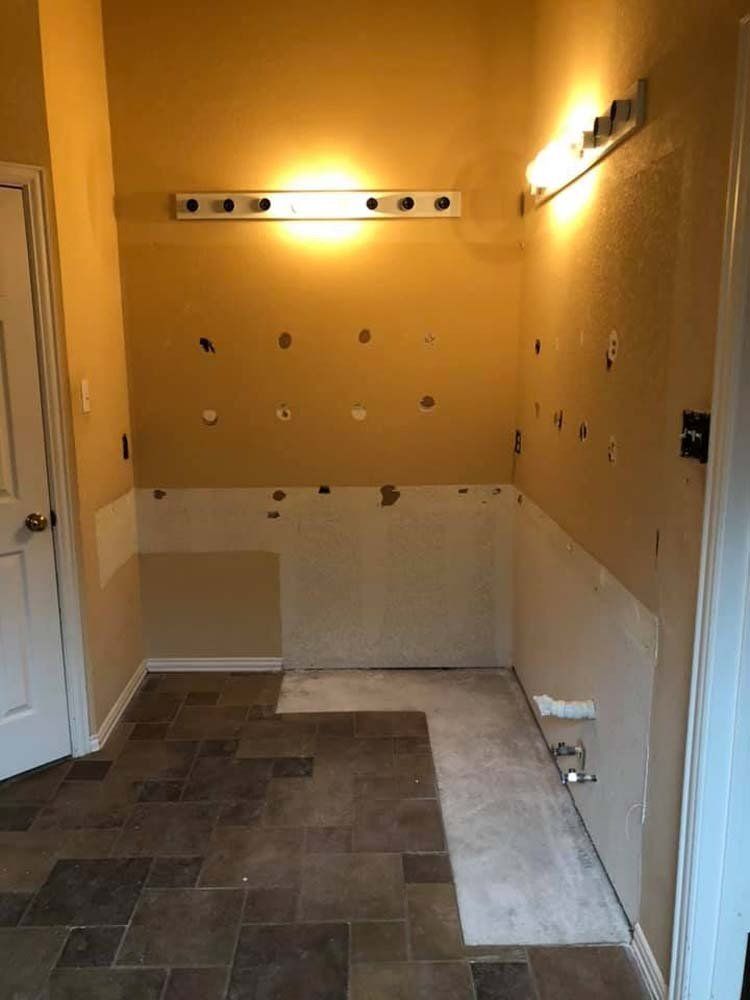 A bathroom with tile floors and a light on the wall.