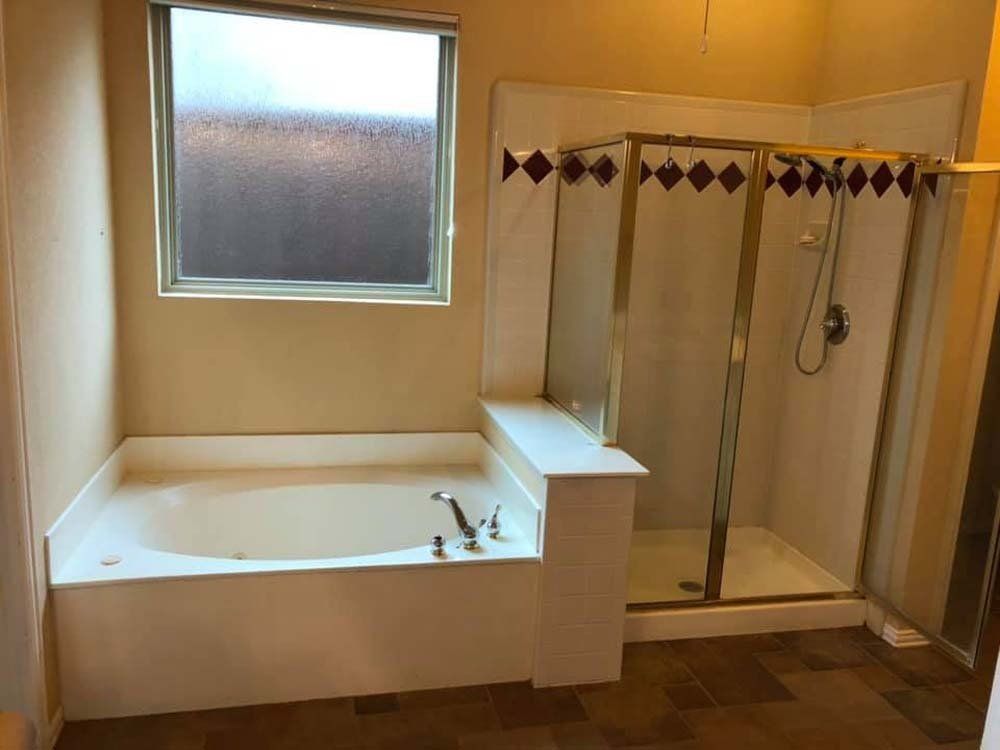 A bathroom with a jacuzzi tub and a walk in shower.