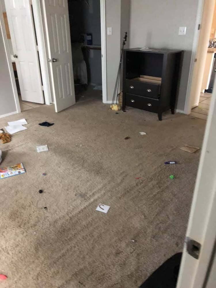 A room with a dirty carpet and a dresser.