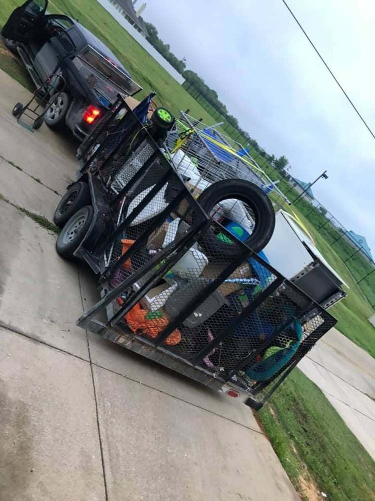 A trailer is sitting on the sidewalk next to a truck.