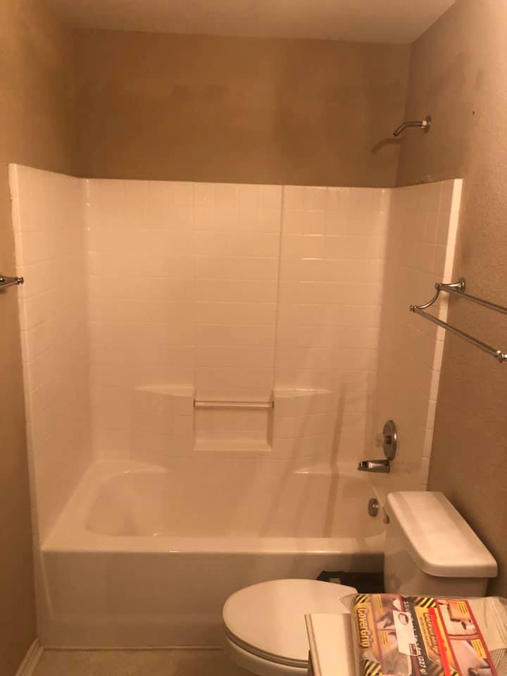 A bathroom with a tub , toilet and shower.