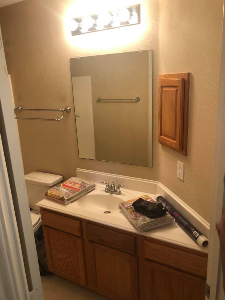 A bathroom with a sink , toilet and mirror.