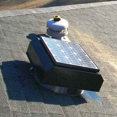 A black solar-powered attic ventilation fan mounted on a gray asphalt-shingled roof.