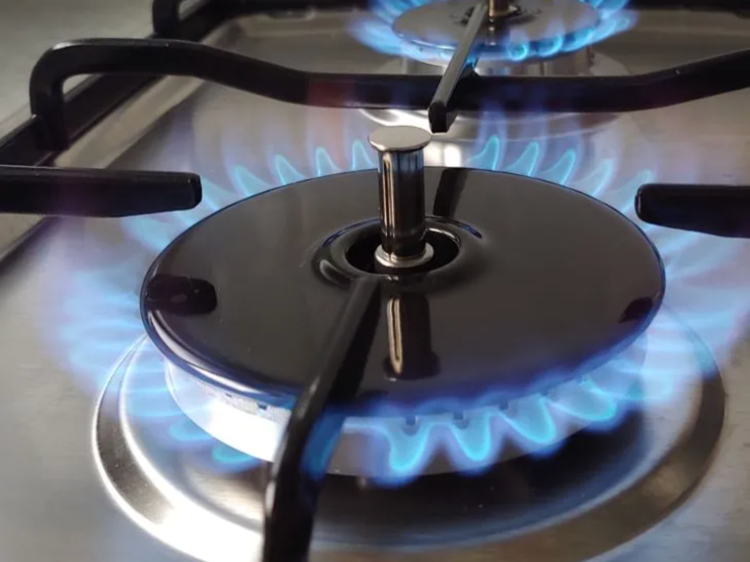 A gas stove top, turned on.