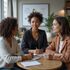 Three women in business attire at a table, discussing notes. Bright setting with a chart on the wall.