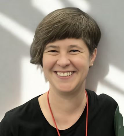 A close-up of a woman with short brown hair who is smiling. 