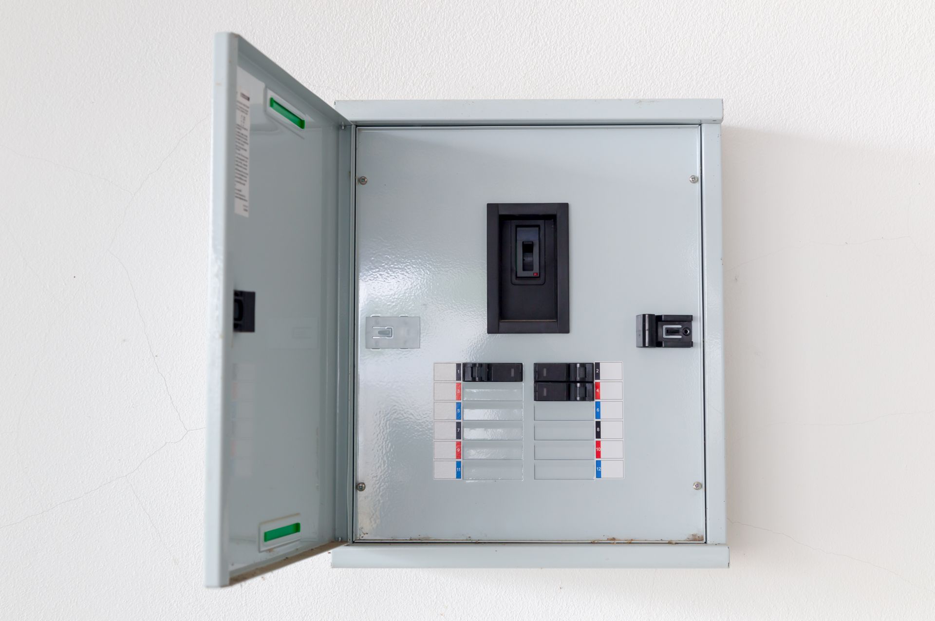Open electrical breaker panel on a white wall, showing circuit breakers and labels. Open electrical breaker panel on a white wall, showing circuit breakers and labels.
