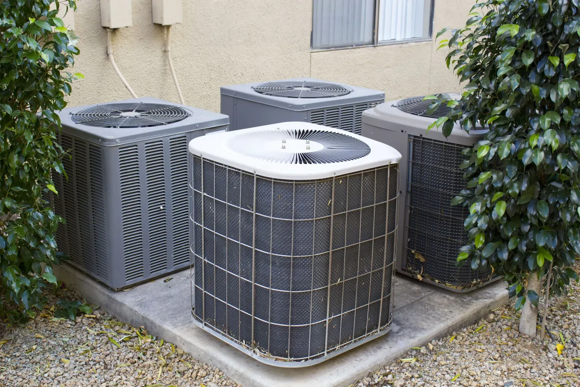 Kenders Heating And Air Conditioning | three air conditioners are sitting outside of a building.