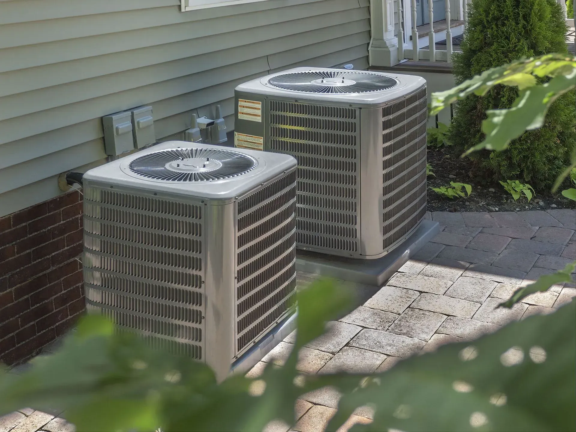 Kenders Heating And Air Conditioning | two air conditioners are sitting on the side of a house.