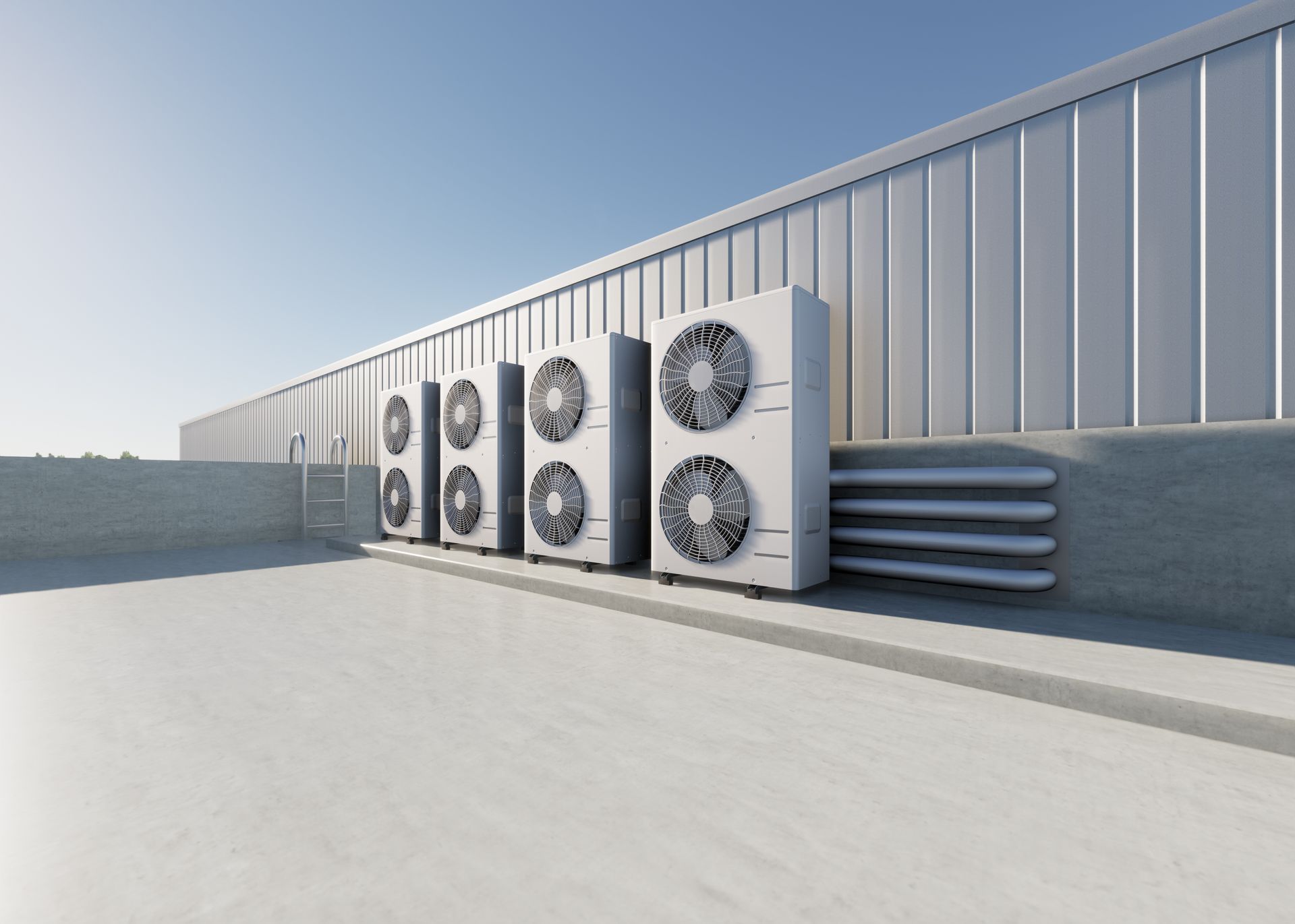 Four outdoor air conditioning units stand in a row on a flat gray roof against a large metal industrial building. Four outdoor air conditioning units stand in a row on a flat gray roof against a large metal industrial building.