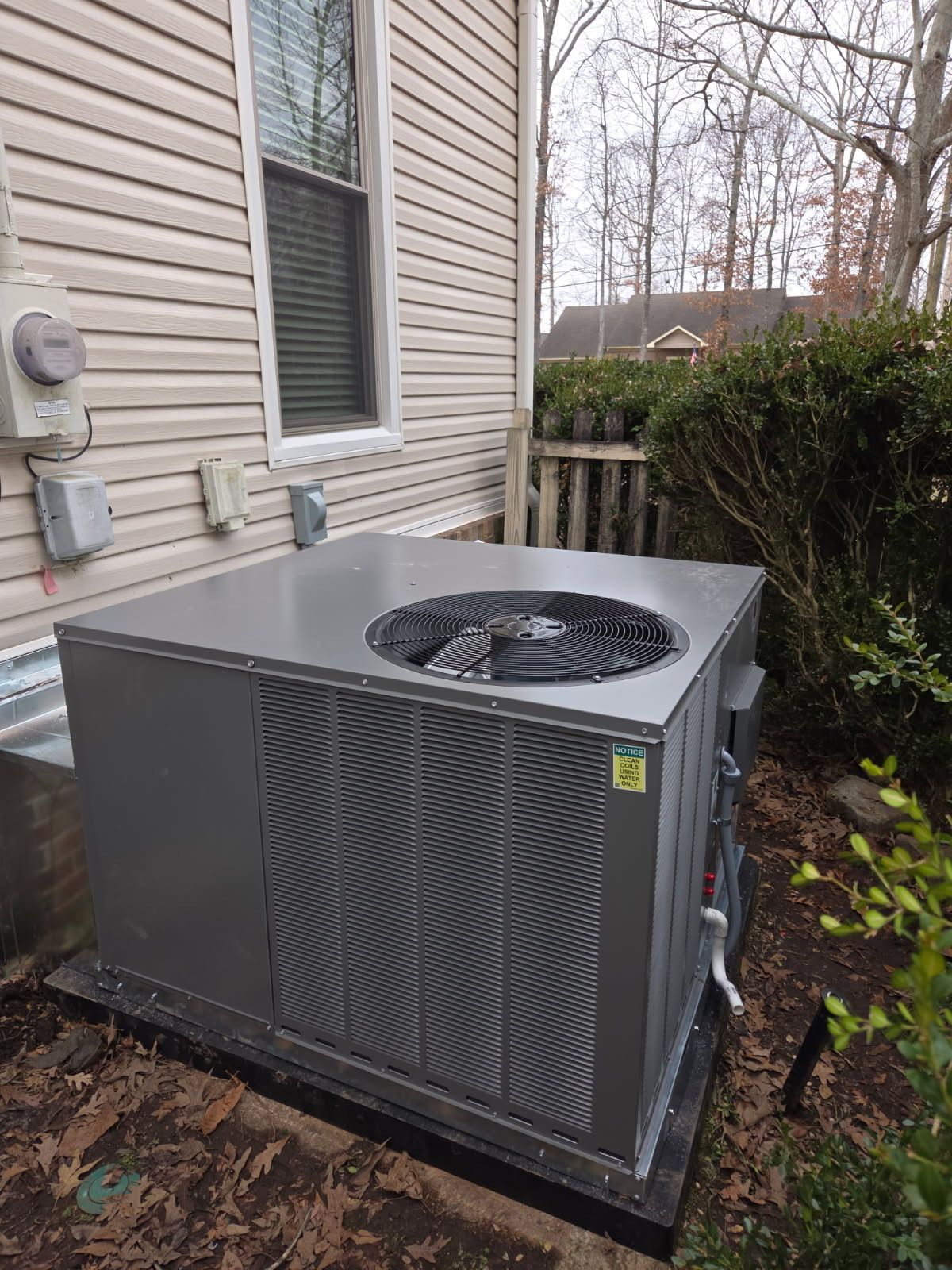Green industrial refrigeration unit on a rooftop platform, with black piping and white components.