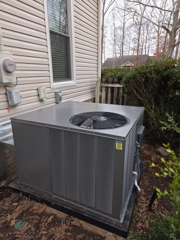 Green industrial refrigeration unit on a rooftop platform, with black piping and white components.