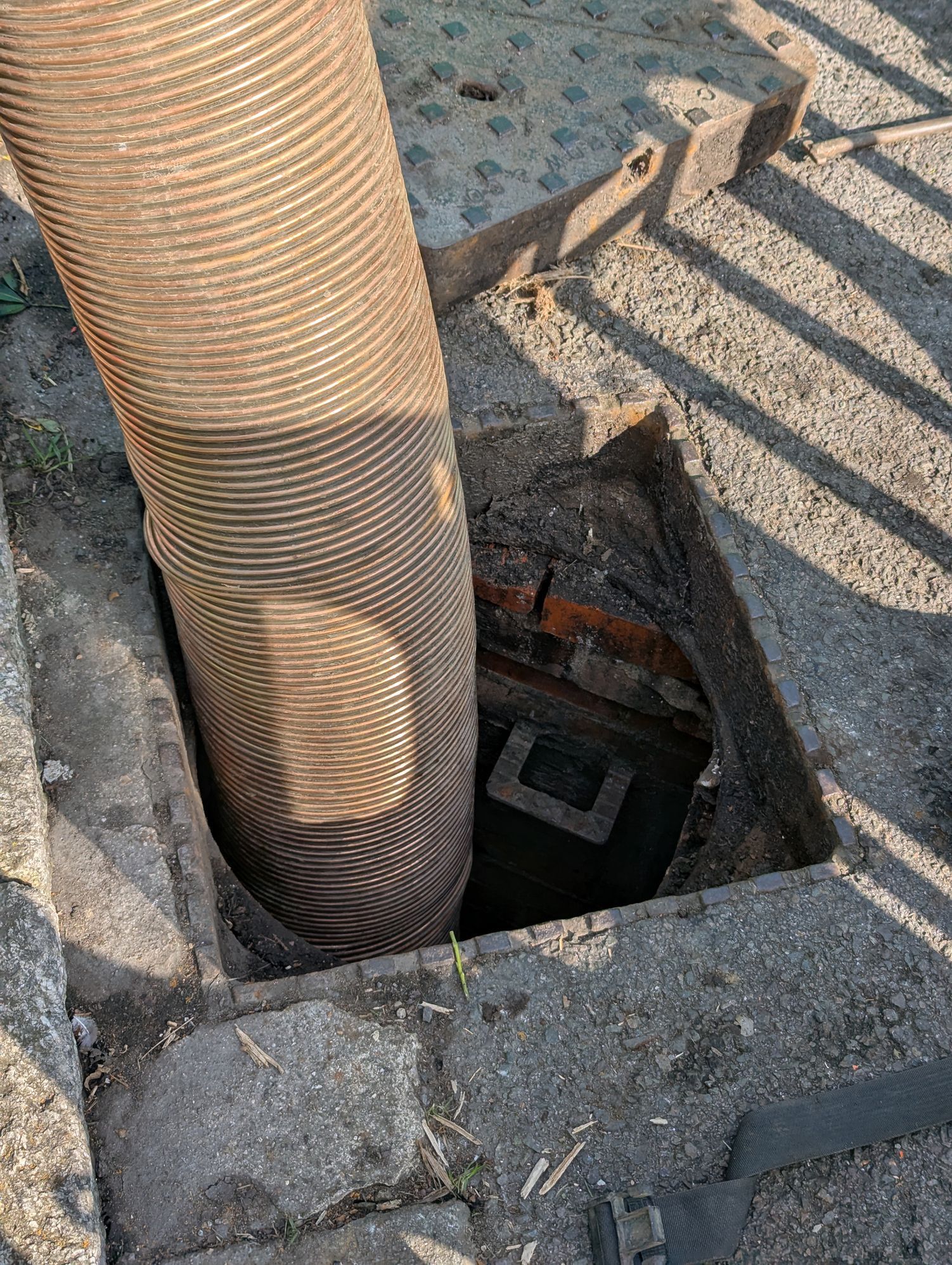 Un grande tubo si estende in una fogna a cielo aperto, fissata al cemento.