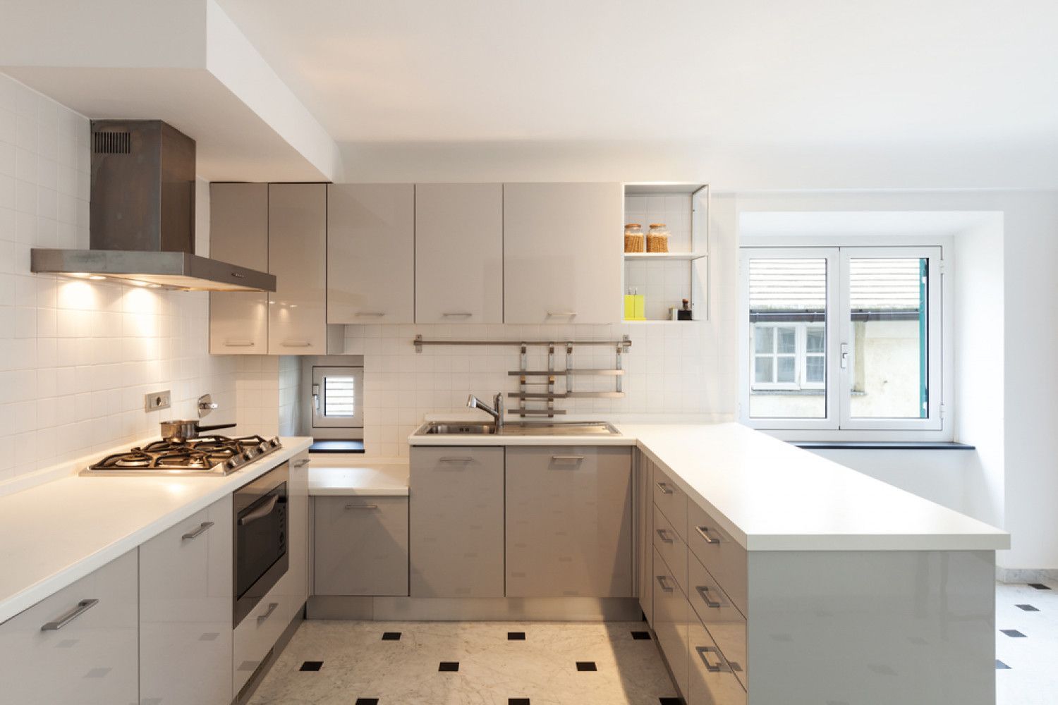 A kitchen with white cabinets and a stove top oven