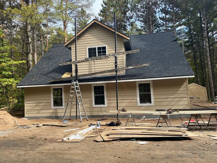 A house that is being built with a black roof