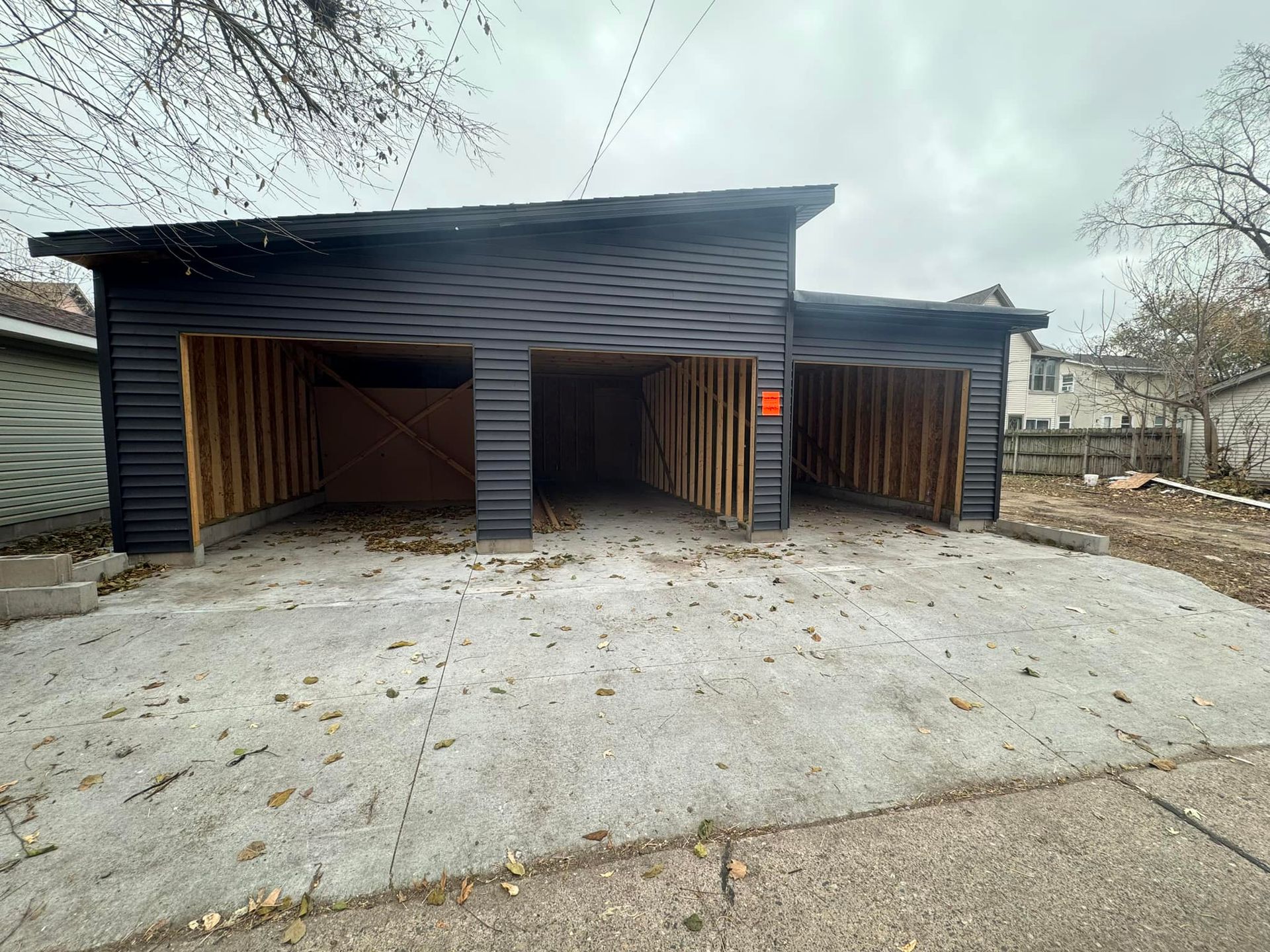 A garage is being built in the backyard of a house.