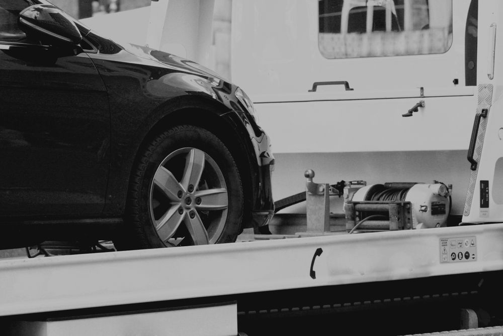 Black Car Being Towed Onto a Tow Truck, Side View — Old Mate's Towing Townsville in Deeragun, QLD