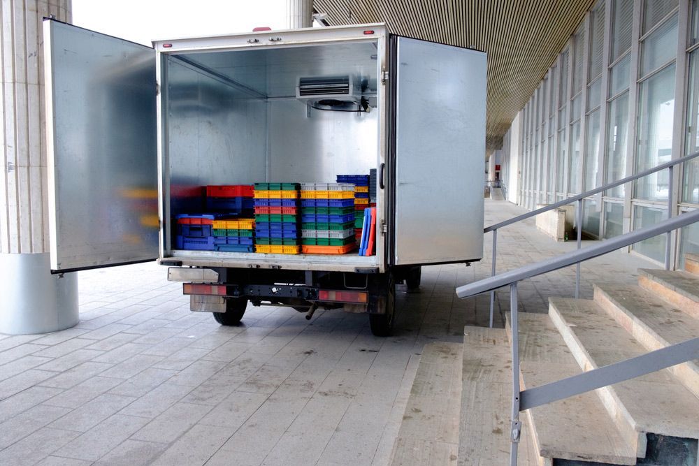 Refrigerated Delivery Truck With Open Doors, Loaded With Colourful Crates — Old Mate's Towing Townsville in Deeragun, QLD