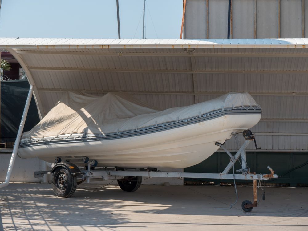 Boat on a Trailer, Covered With a Tarp, Under a Metal Roof Structure — Old Mate's Towing Townsville in Deeragun, QLD