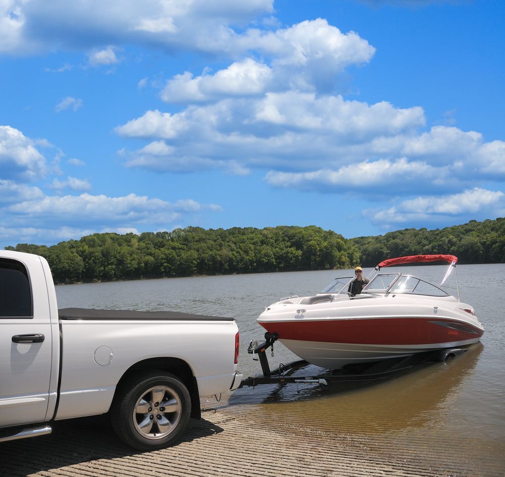 White Truck Towing a Red and White Boat Out of the Water — Old Mate's Towing Townsville in Deeragun, QLD