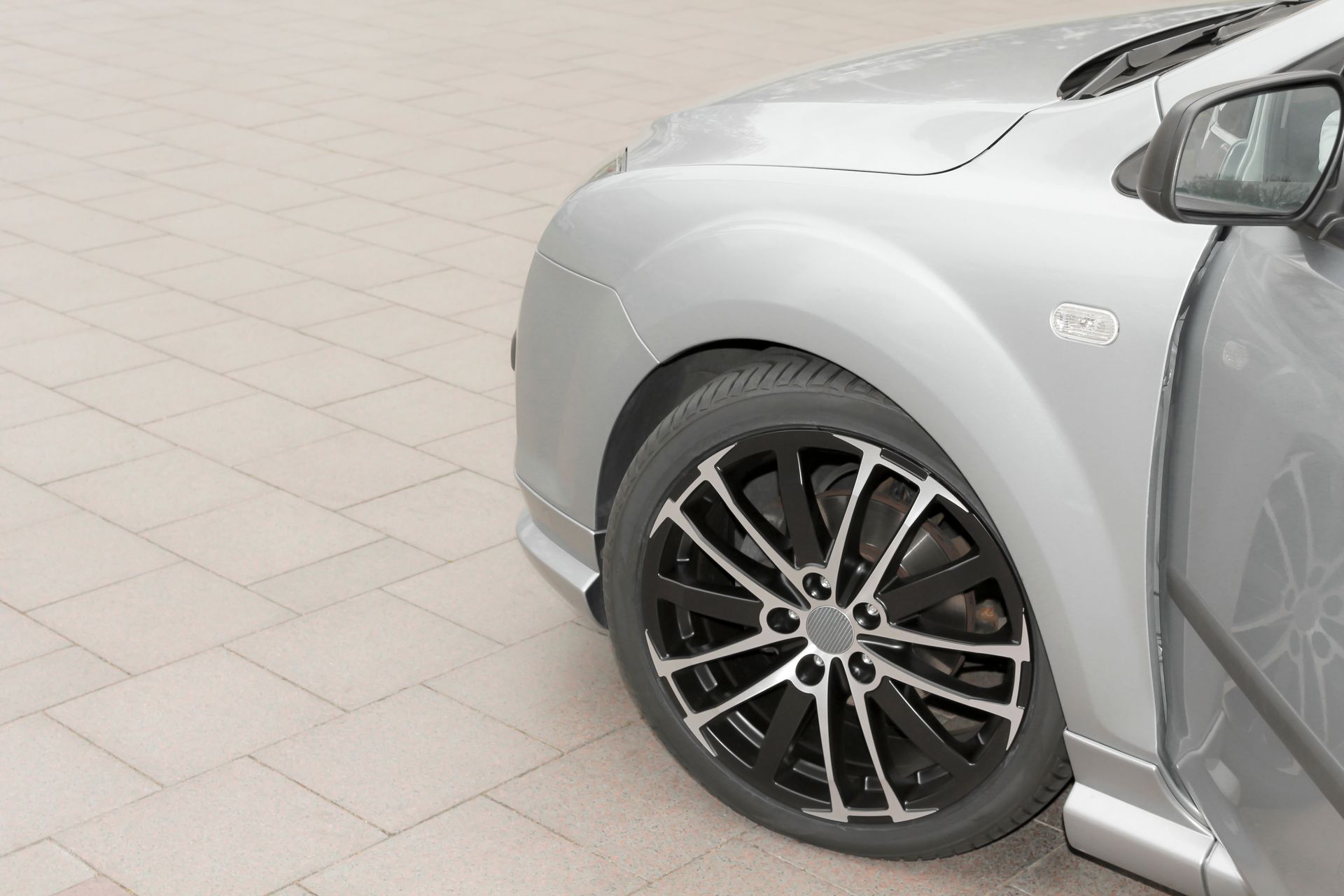 Silver Car Front Quarter With Black and Silver Wheel on Brick Pavers — Old Mate's Towing Townsville in Deeragun, QLD