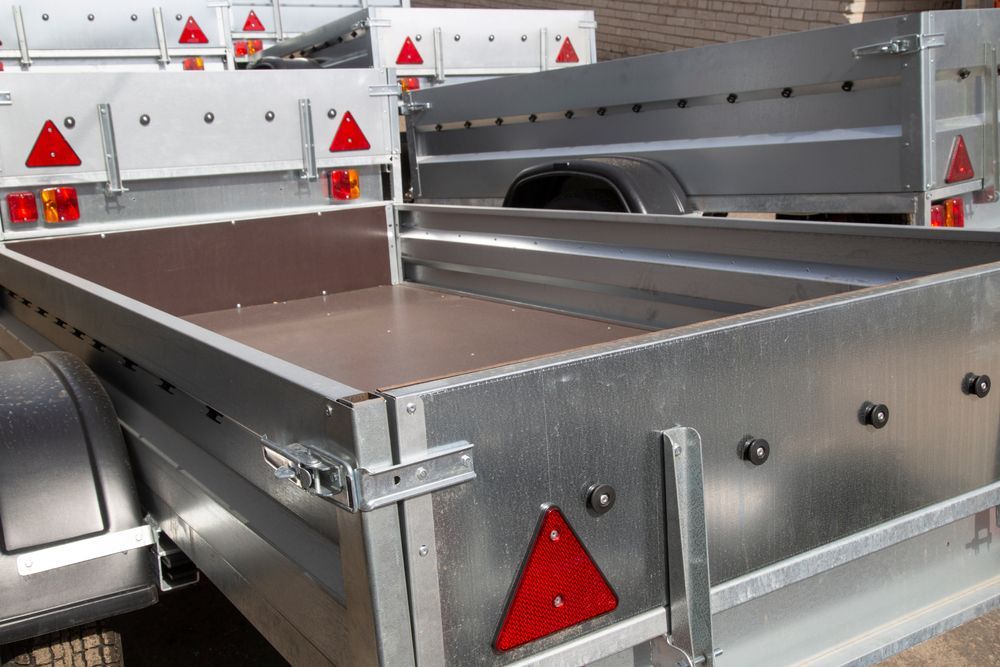 Several Silver Utility Trailers With Red Reflector Triangles, Outdoors — Old Mate's Towing Townsville in Deeragun, QLD