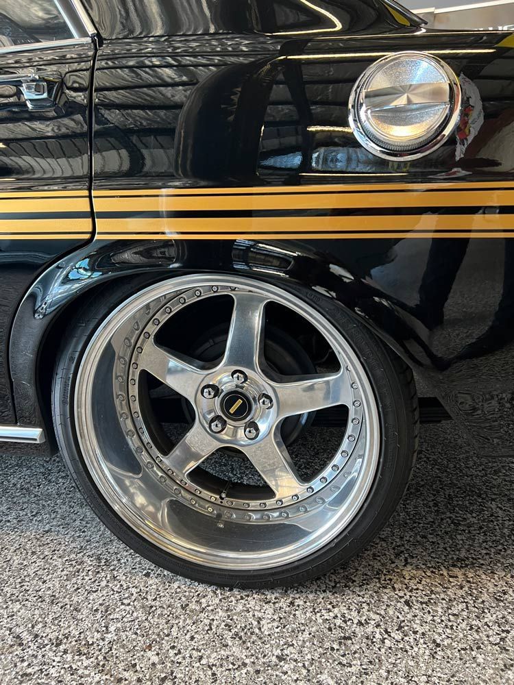 A Black Car with Yellow Stripes on The Side Is Parked in A Garage — Powatone Exhaust Centre in Fyshwick, ACT
