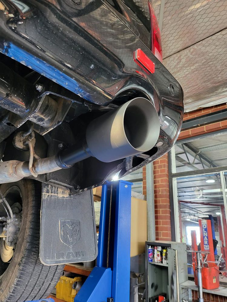 Close Up Muffler of A Car on a Lift — Powatone Exhaust Centre in Fyshwick, ACT