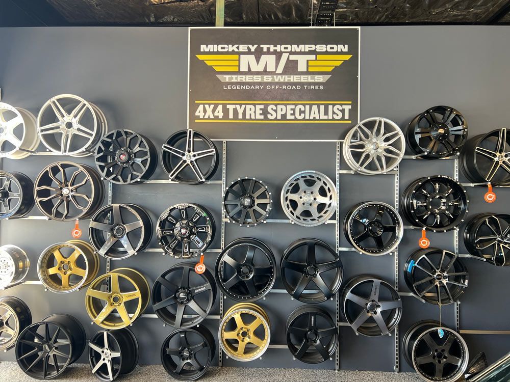 A Wall of Wheels and A Sign that Says Mickey Thompson 4x4 Tyre Specialist — Powatone Exhaust Centre in Fyshwick, ACT