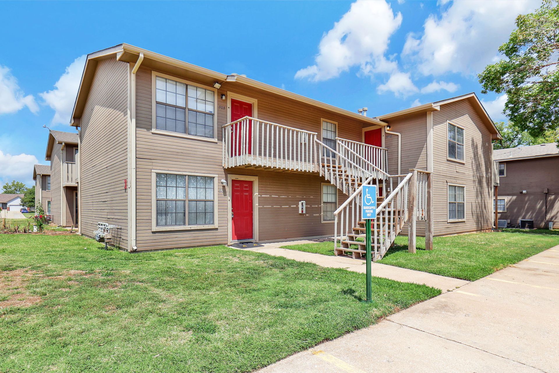 A large apartment building with stairs leading up to the second floor.