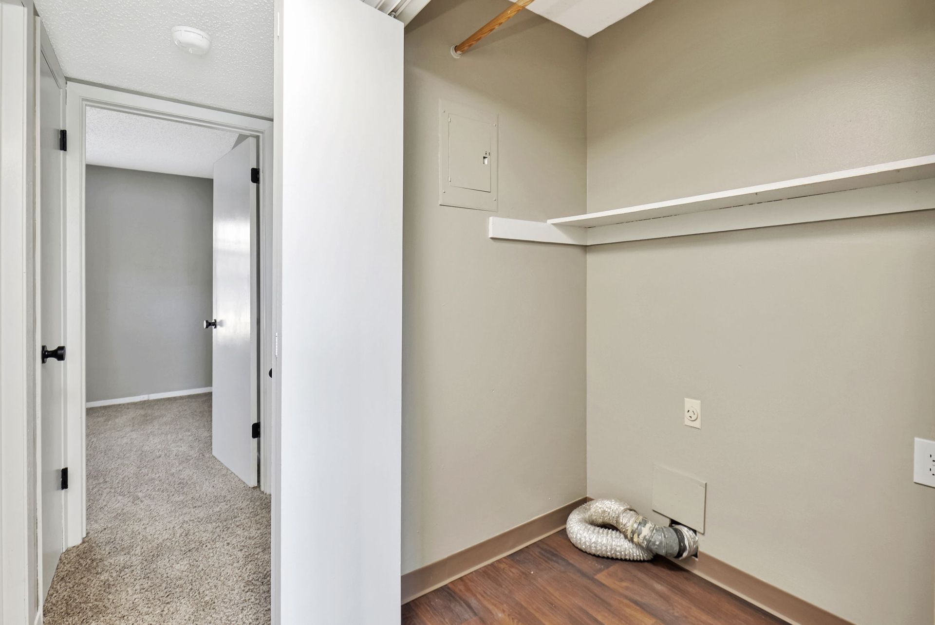 A closet in a house with a hose on the floor.