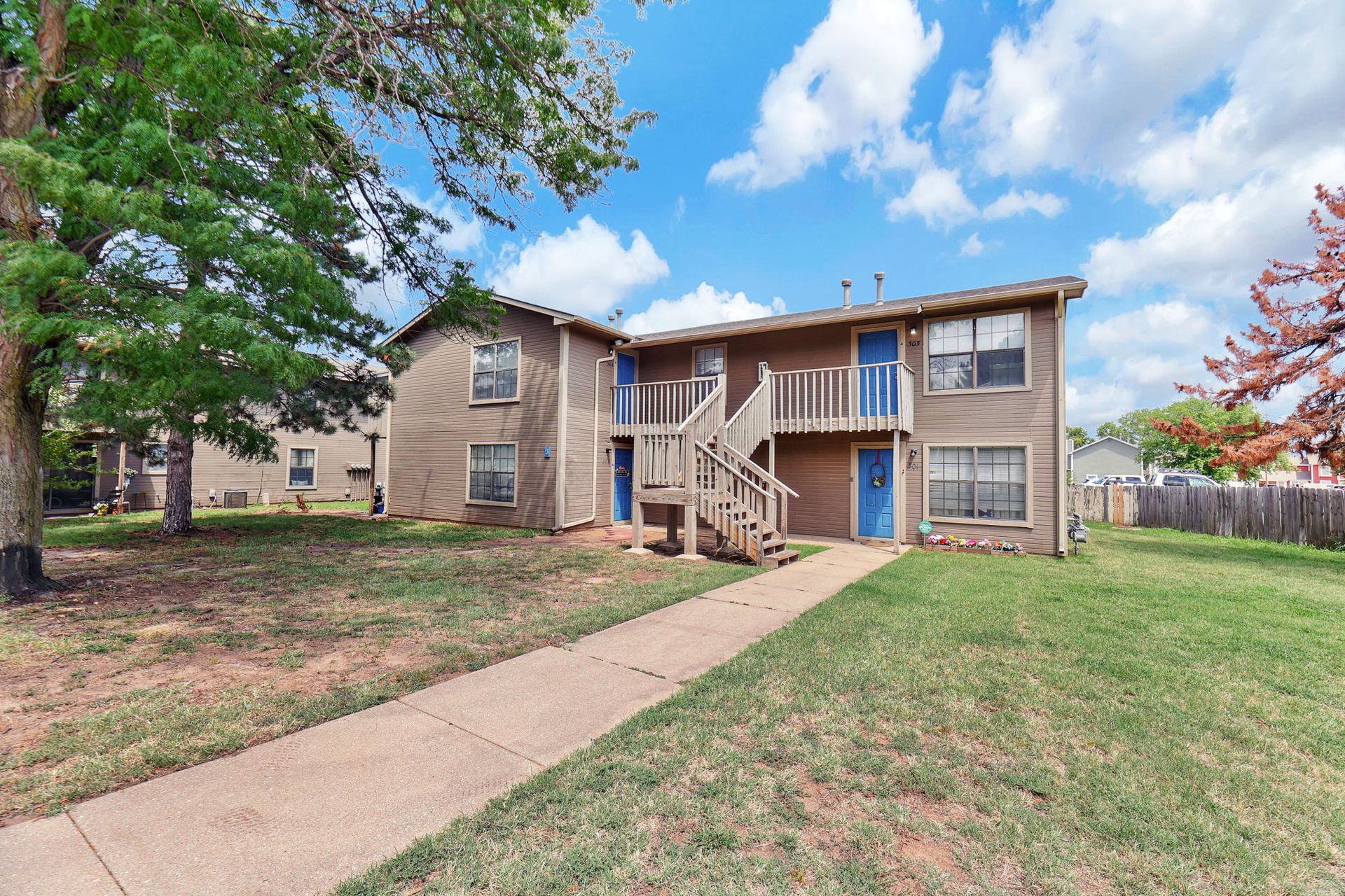 A large apartment building with stairs leading up to the second floor.