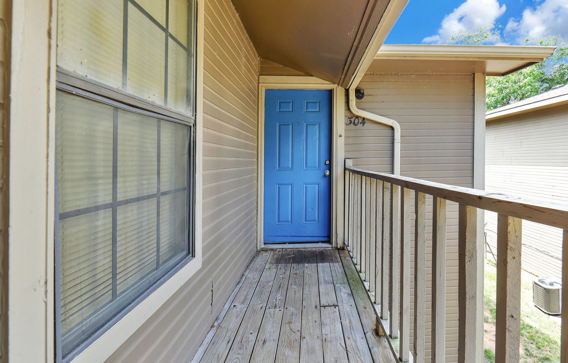 A blue door is on the side of a house
