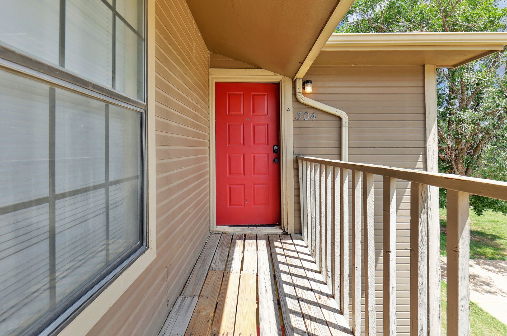 A red door is on the side of a house
