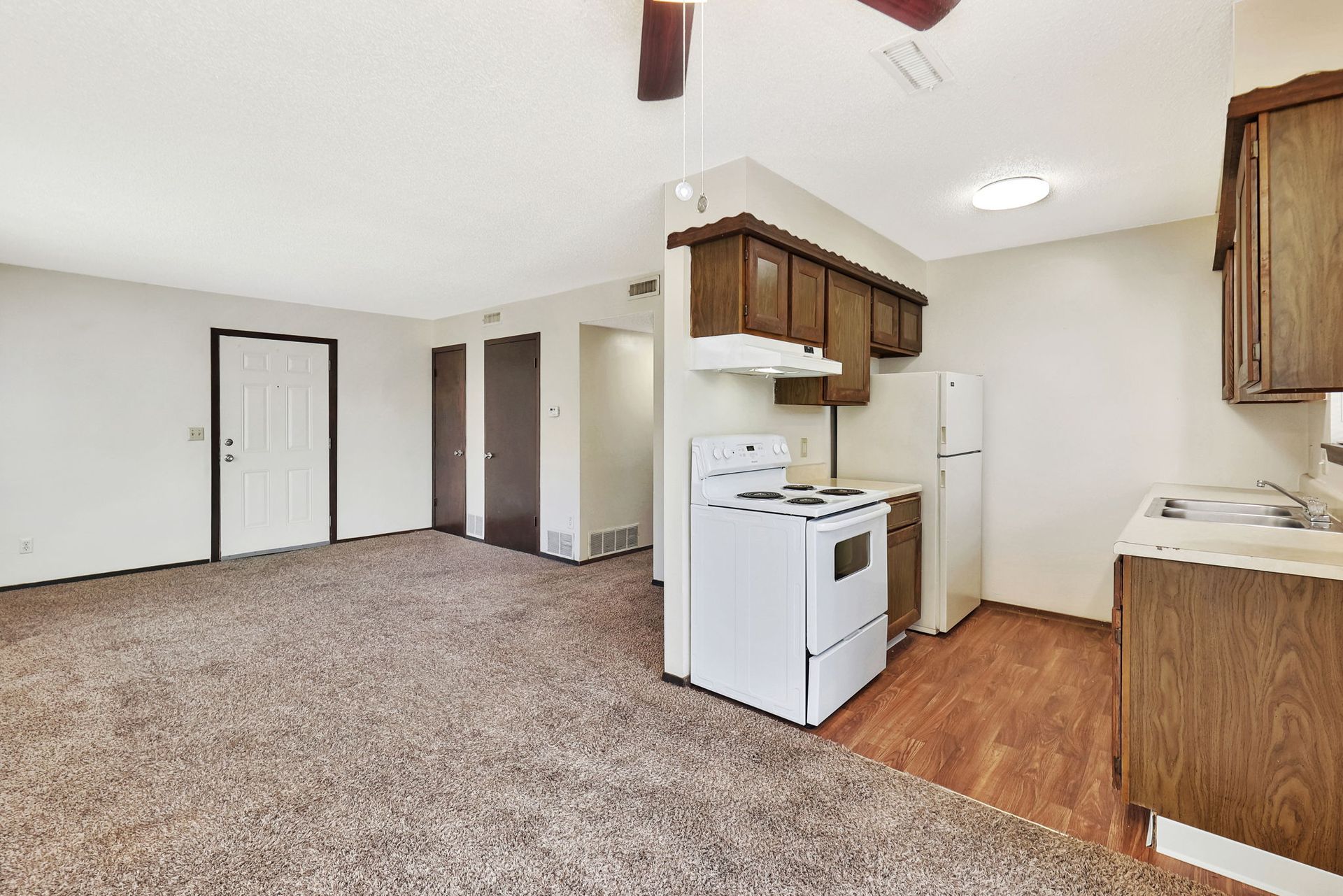 A kitchen with a white stove and a refrigerator