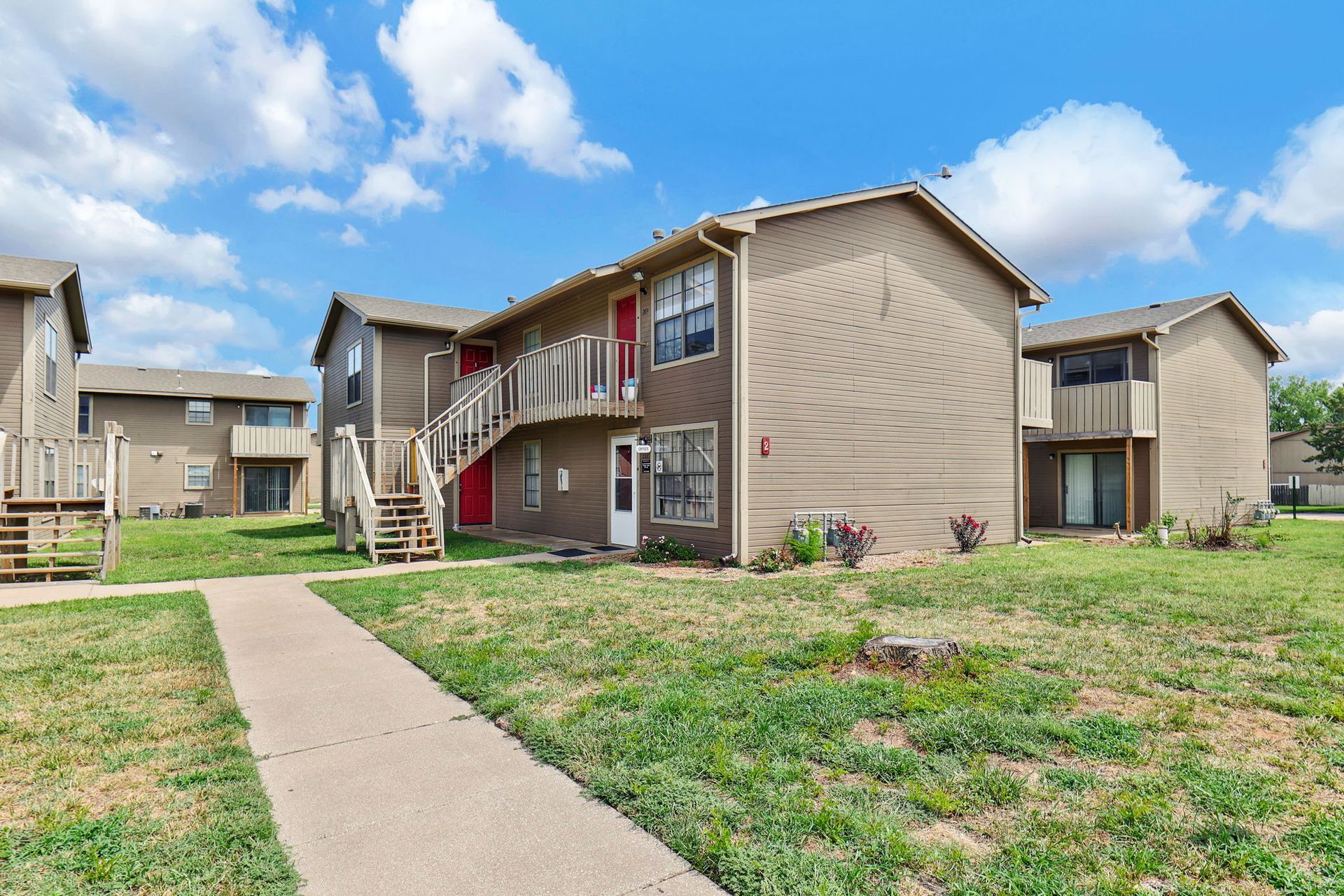 A large apartment building with stairs leading up to the second floor.