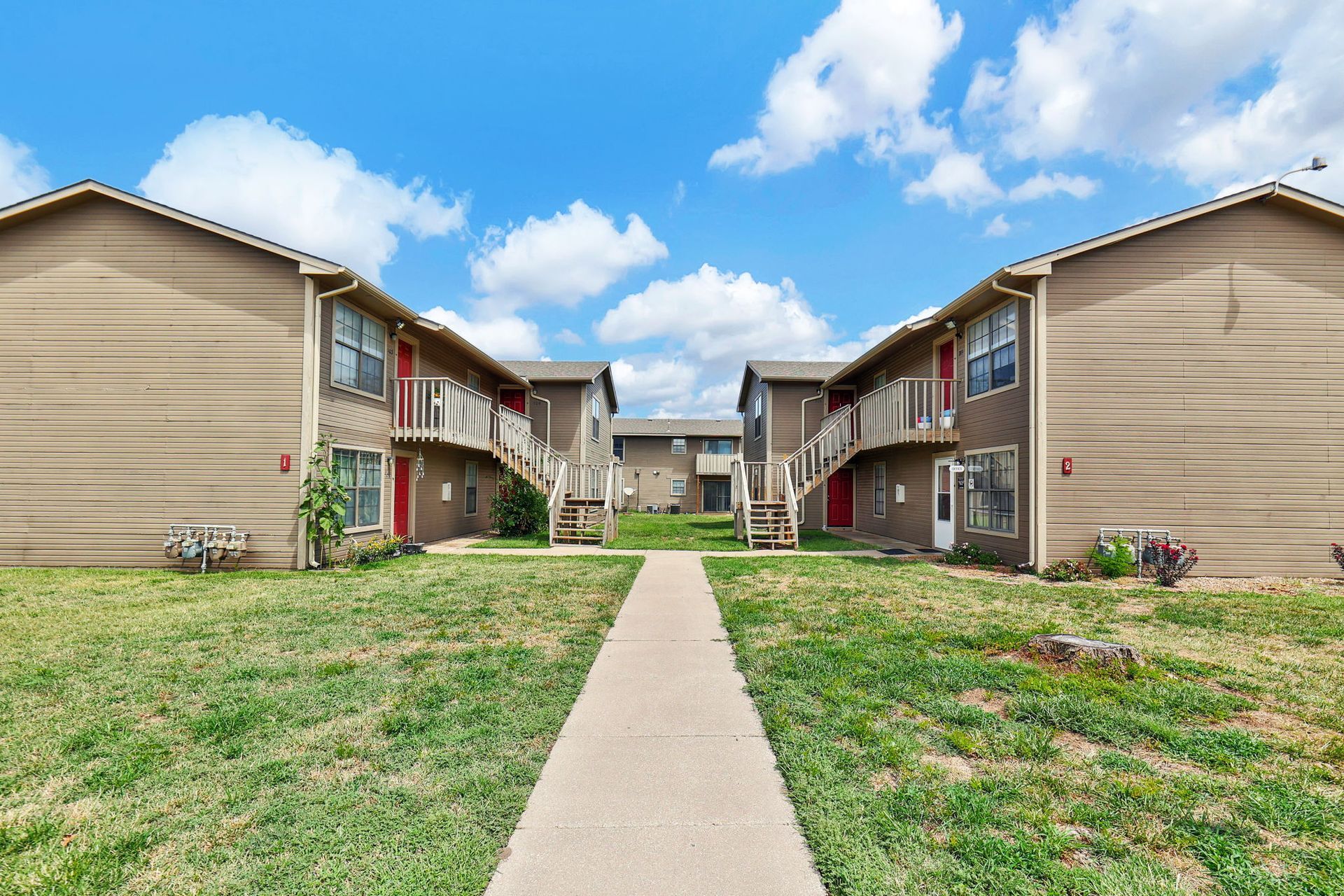 A row of apartment buildings with a walkway between them.