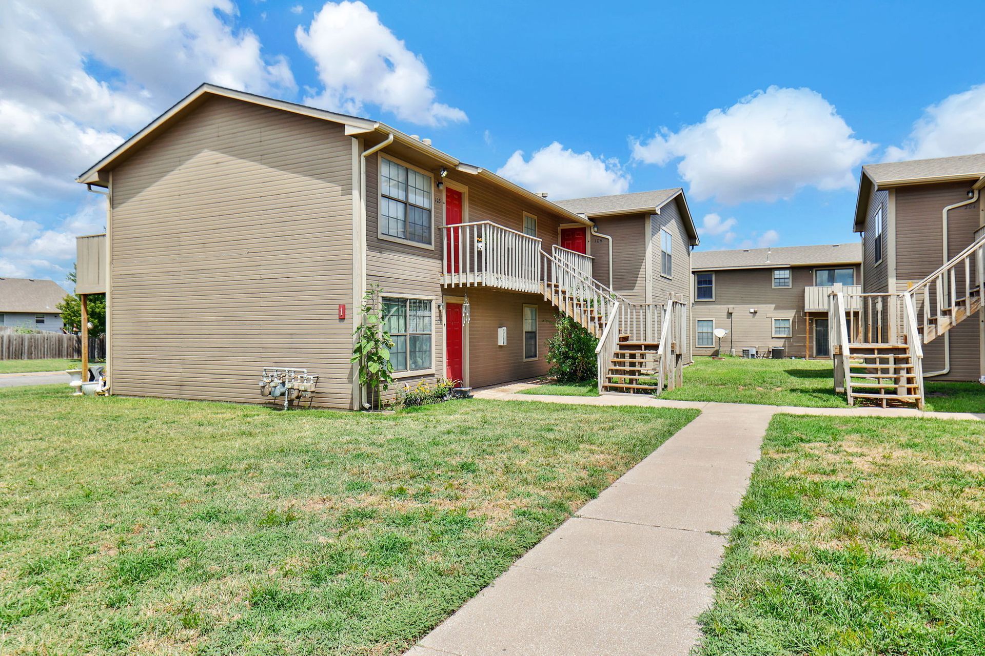 A large apartment building with stairs leading up to the second floor.