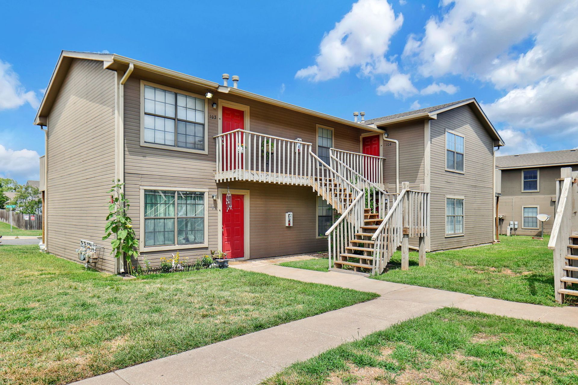 A large apartment building with stairs leading up to the second floor.