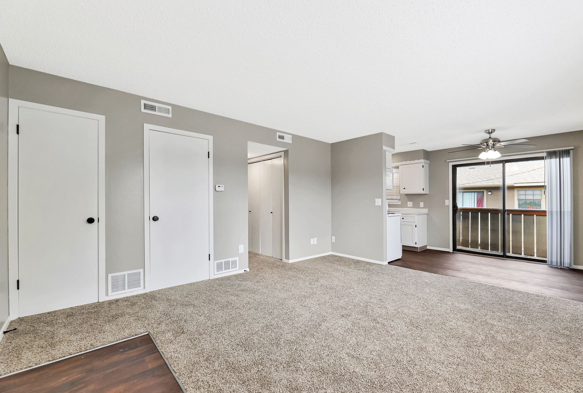 A living room with a sliding glass door and a balcony.