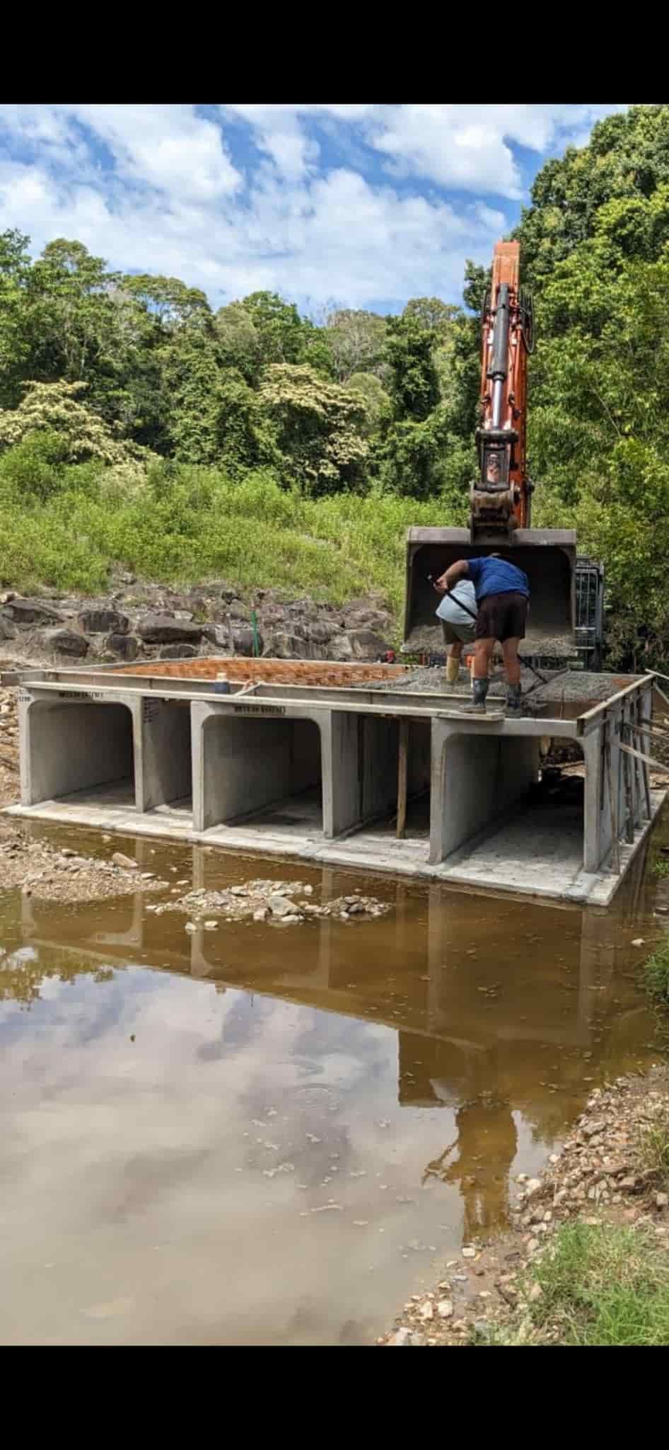 A Man is Standing on Top of a Concrete Structure Next to a Body of Water — Gears Excavation In Cedar Pocket, QLD