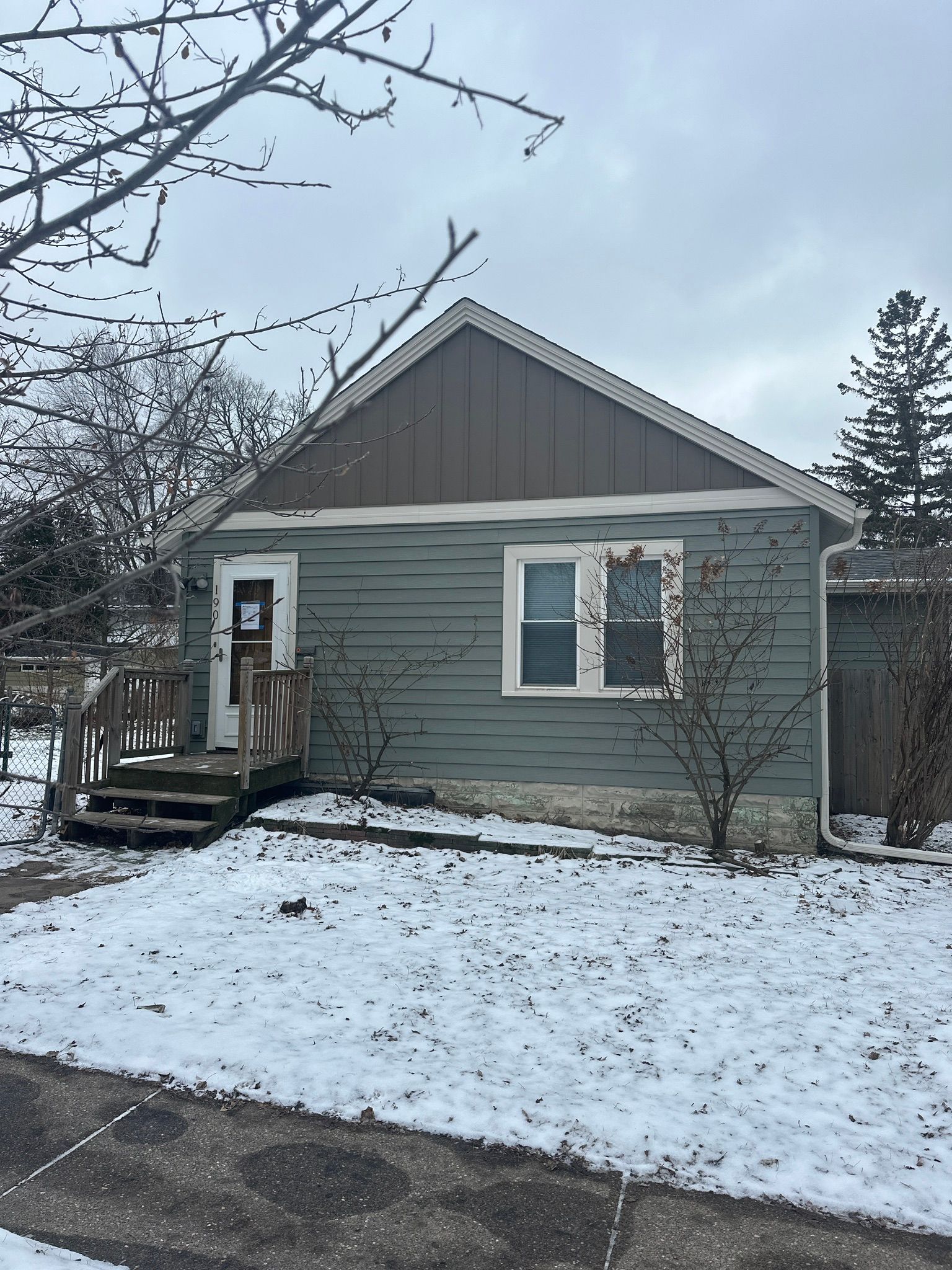 A small house with a deck in the snow.